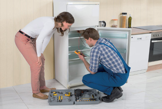 Мастер-ремонтник за ремонтом холодильника